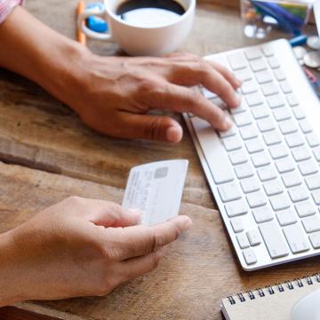 Una persona paga de forma segura una compra en línea con una tarjeta de crédito. Compre y realice transacciones en línea de forma segura y sencilla.